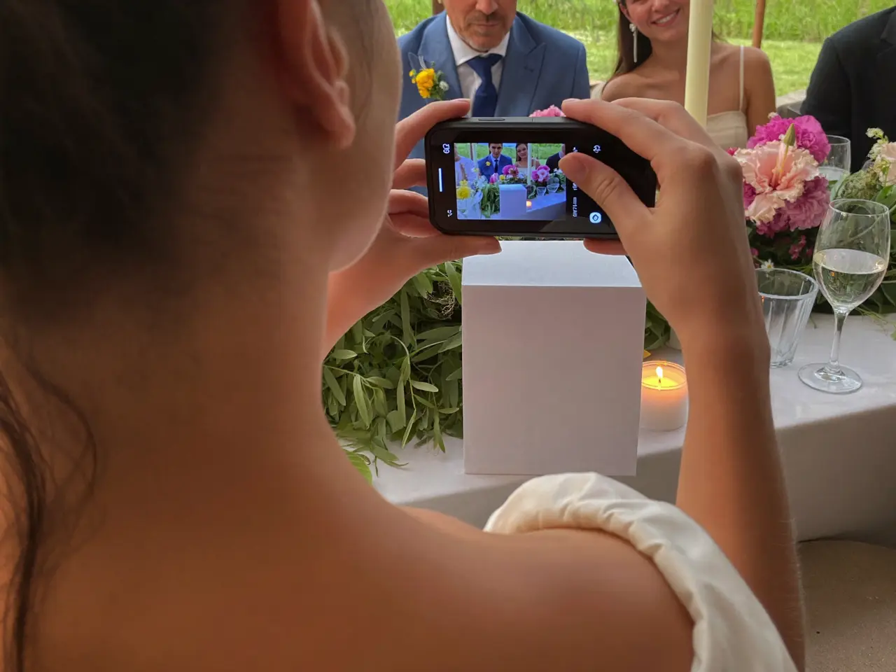 A guest scanning the card on the wedding table with her phone