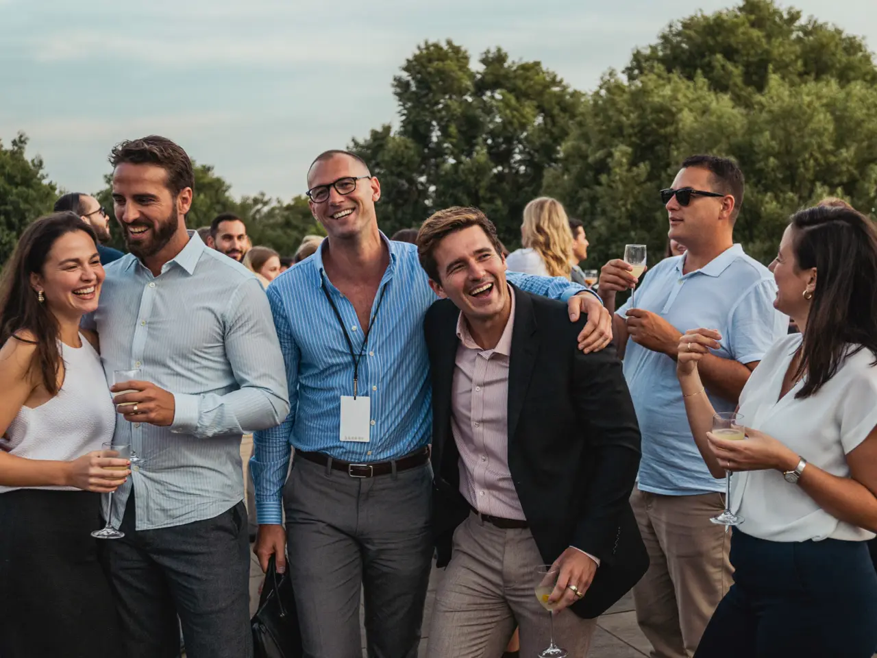 Colleagues laughing at a summer office party on a terrace